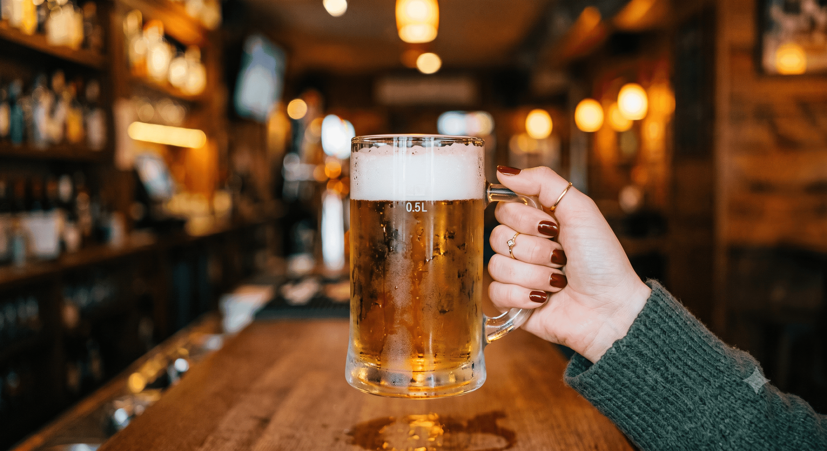 Hand hält ein frisch gezapftes Bierglas